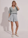 Short sleeve knitted honeycomb top with notch neckline and aesthetic buttons in a light sage green