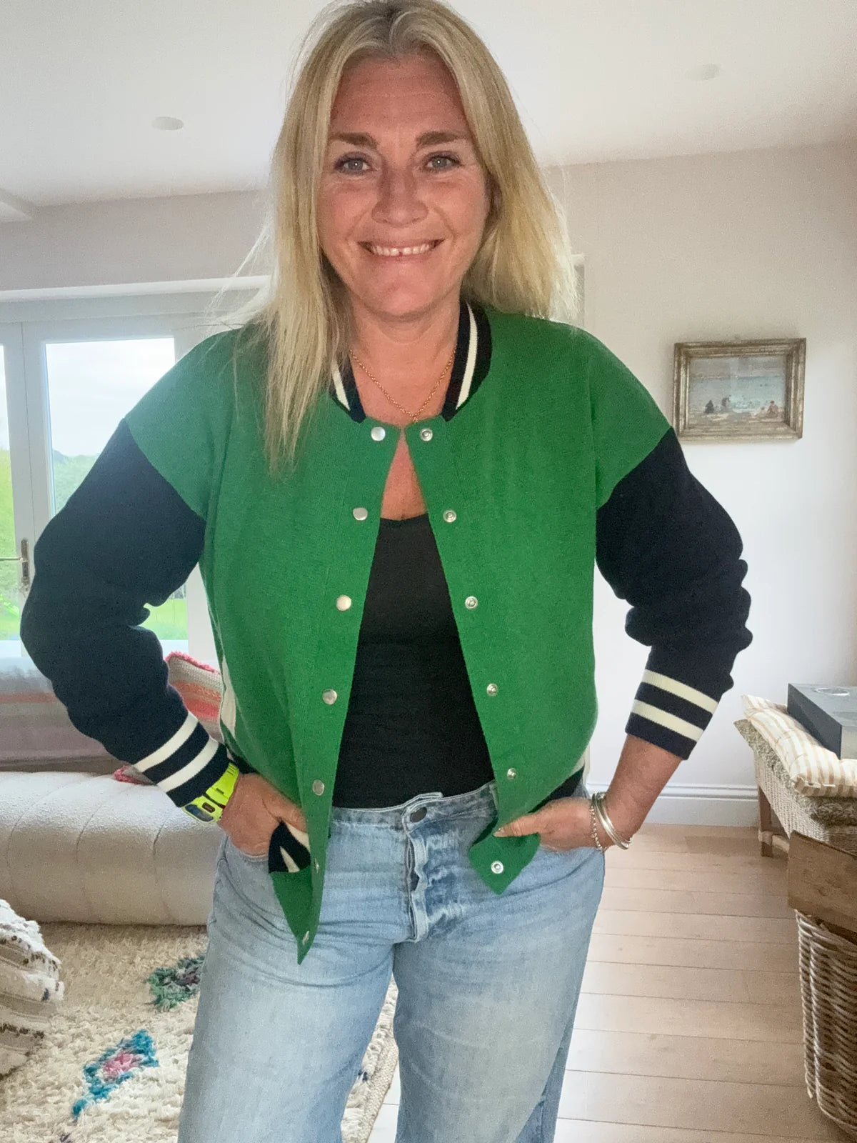 Knitted green bomber jacket with navy sleeves and white details with silver popper closures