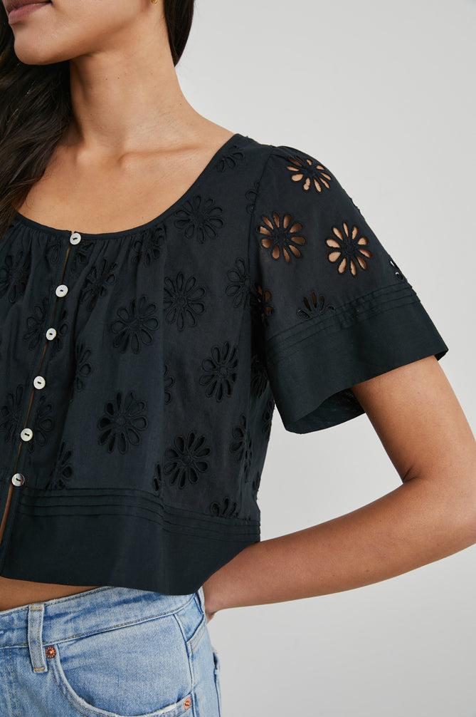 Daisy style broderie anglais top in black with short sleeves and a scoop neck close up of sleeve