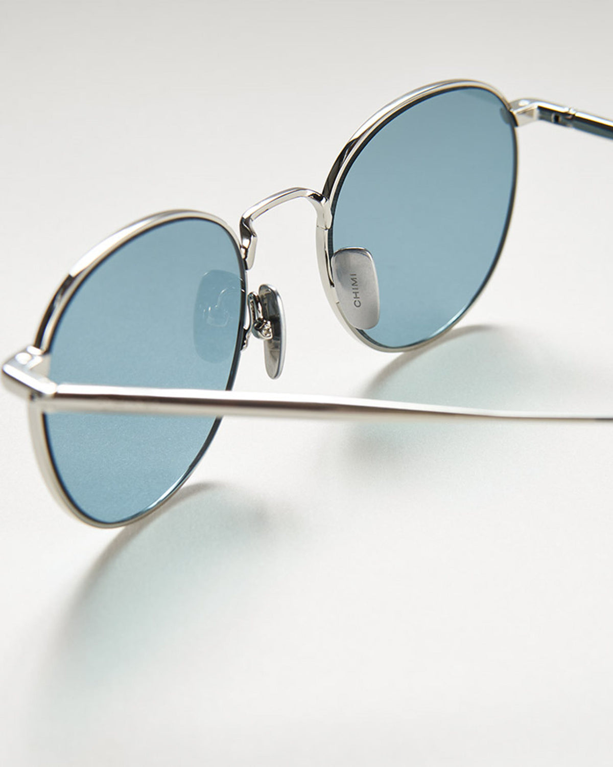 Steel frame round sunglasses with a blue lense