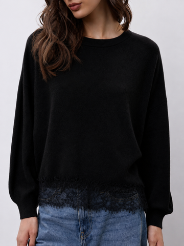 model wearing a black crew neckline knit with lace hem and blue jeans 
