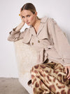 Model shot of beige knitted trench coat worn with skirt