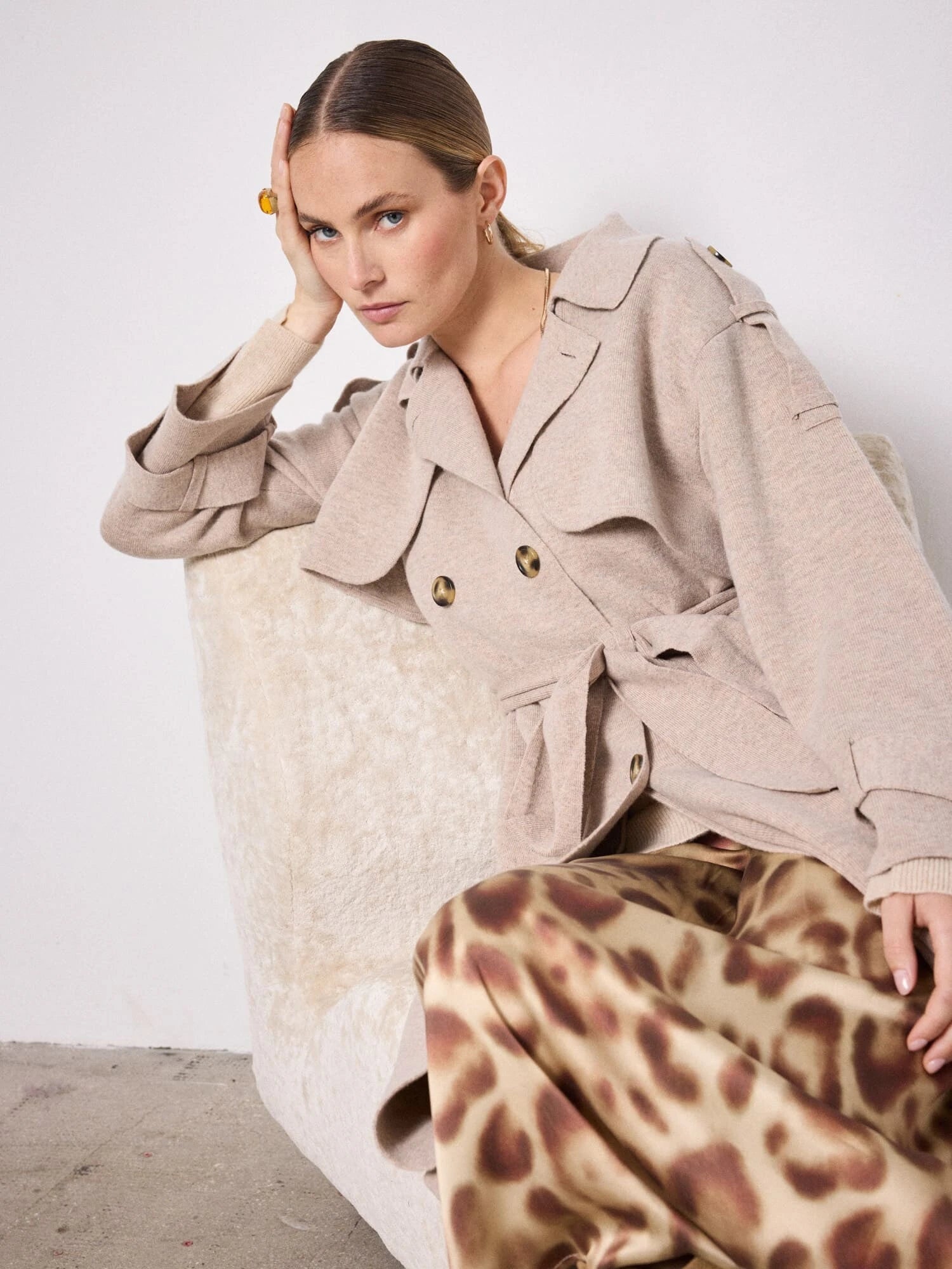 Model shot of beige knitted trench coat worn with skirt