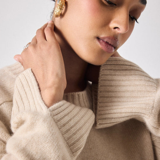 beige cashmere knit with ribbed neck and split cuffs  close up