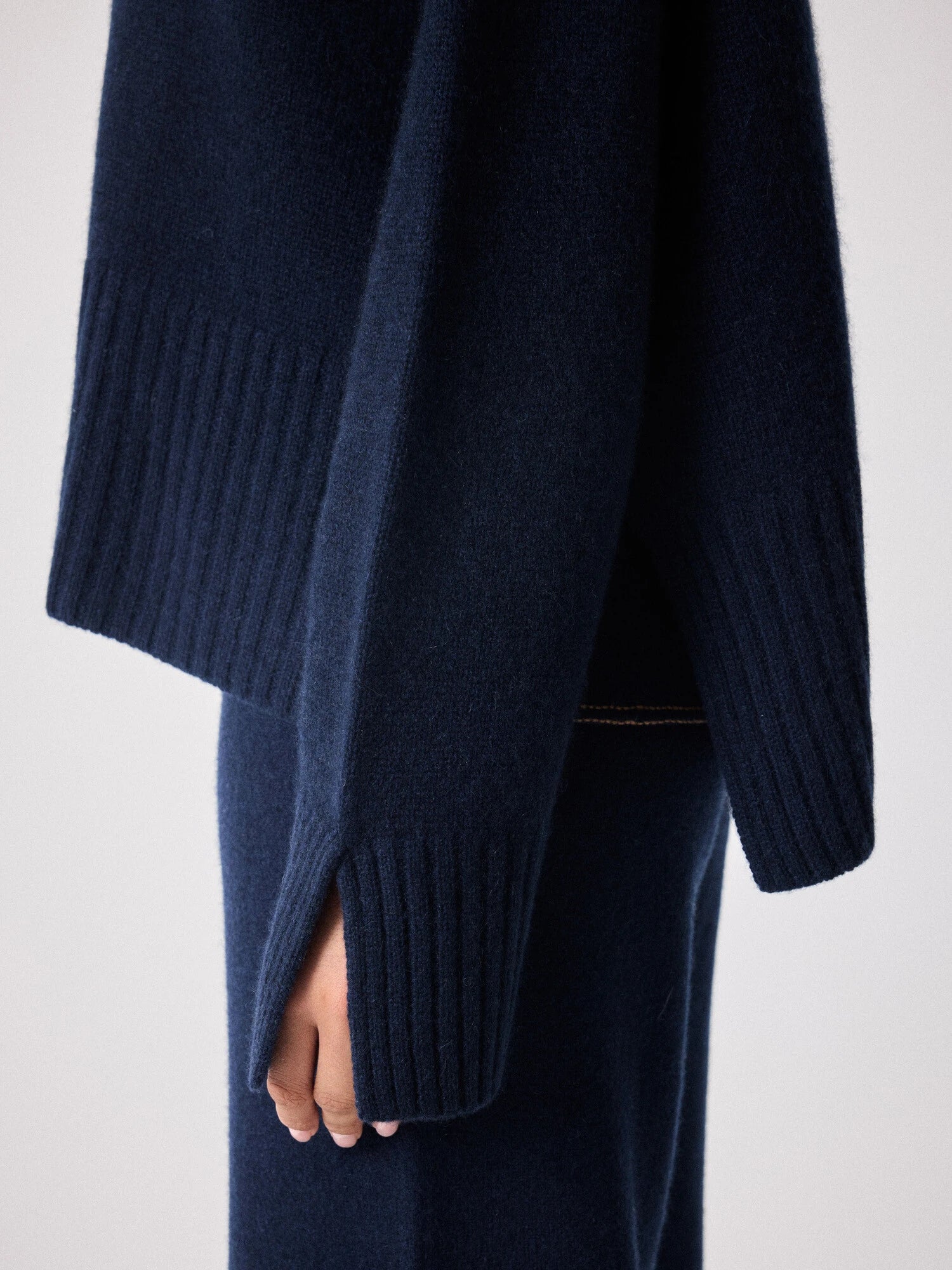 navy cashmere knit with round ribbed neck and split cuffs close up