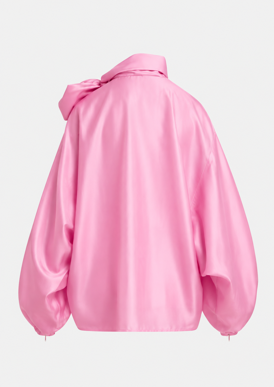 A pink satin blouse with a large bow at the high neck, balloon sleeves, and gathered cuffs, shown on a plain light gray background.