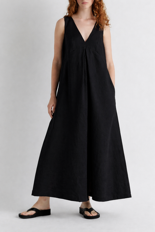 Woman wearing a black sleeveless dress on a plain background