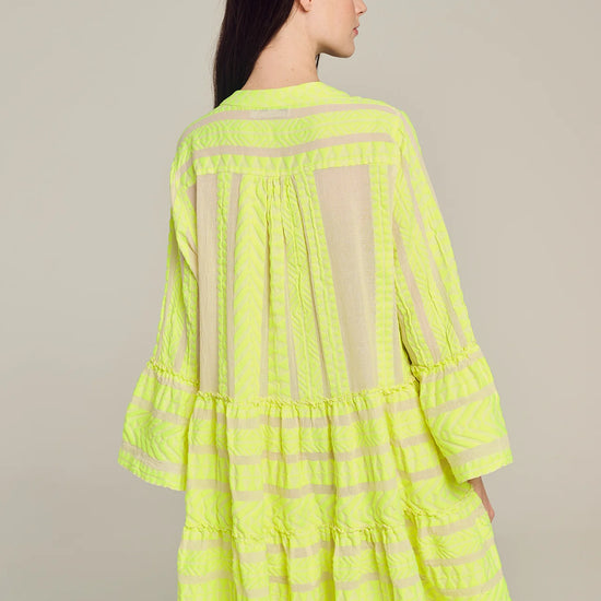 Ecru notch neck above the knee dress with long fluted sleeves and tripe tiered A line skirt with neon lime embroidery throughout