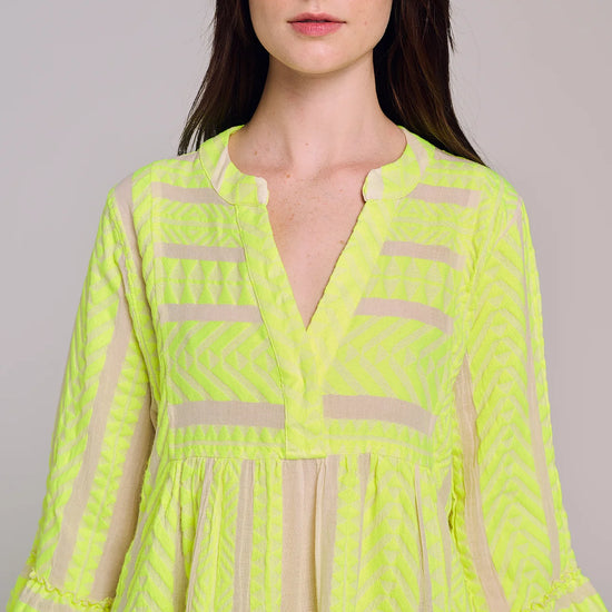 Ecru notch neck above the knee dress with long fluted sleeves and tripe tiered A line skirt with neon lime embroidery throughout