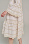 Ecru notch neck midi dress with long fluted sleeves and tripe tiered A line skirt with off-white embroidery throughout