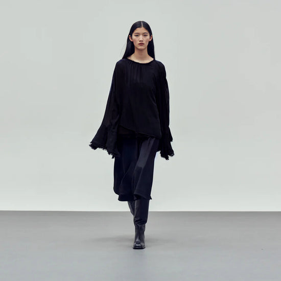 black pull on blouse with long sleeves and fluted cuff detail