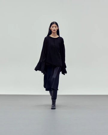 black pull on blouse with long sleeves and fluted cuff detail