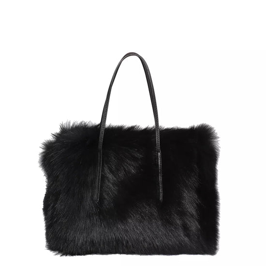 black rectangular small shearling bag with a small top handle and removable cross body strap from abro