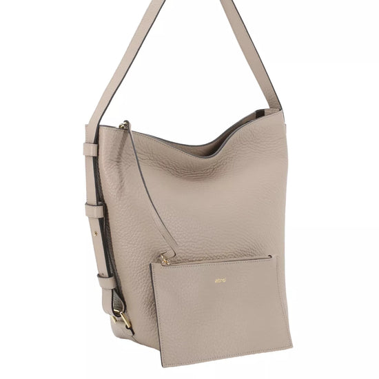 A taupe pebbled leather hobo shoulder bag with a front zippered pocket and a matching adjustable shoulder strap, shown on a plain white background.