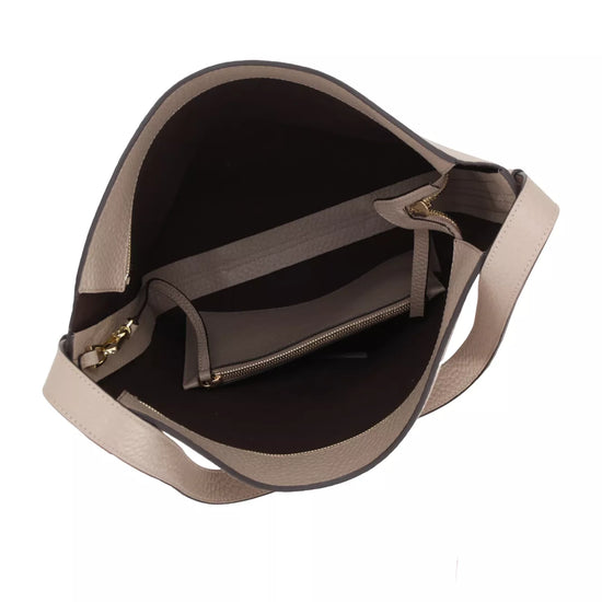 An overhead view of a taupe leather shoulder bag showing its interior, which features a dark brown lining, a zippered pocket, and a matching taupe shoulder strap on a white background.