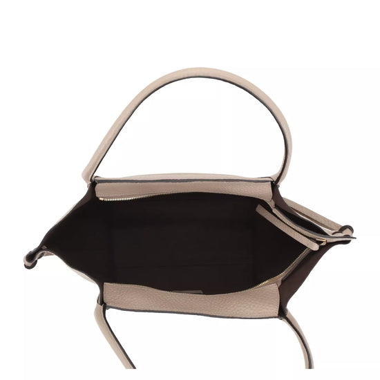 The interior view of a structured handbag with a light beige leather exterior, a black fabric lining, and a single top handle, shown against a plain white background.