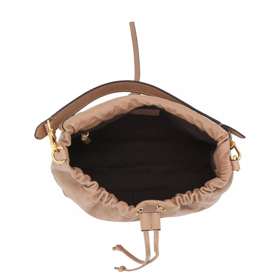 A top-down view of a beige leather bucket bag with a black interior lining and gold-tone hardware, shown on a plain white background.