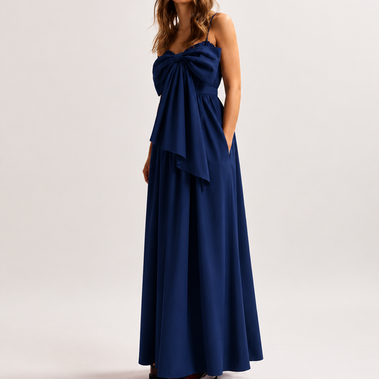 Woman wearing a blue dress with a bow detail on a white background