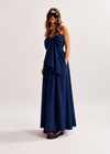 Woman wearing a blue dress with a bow detail on a white background
