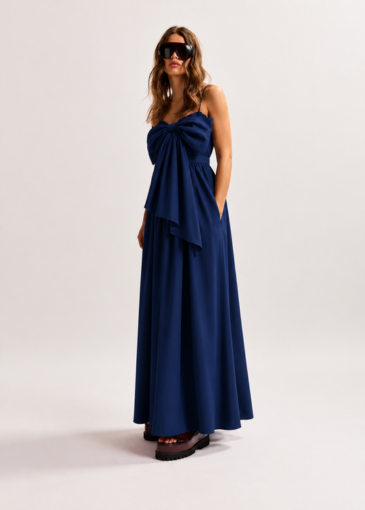 Woman wearing a blue dress with a bow detail on a white background