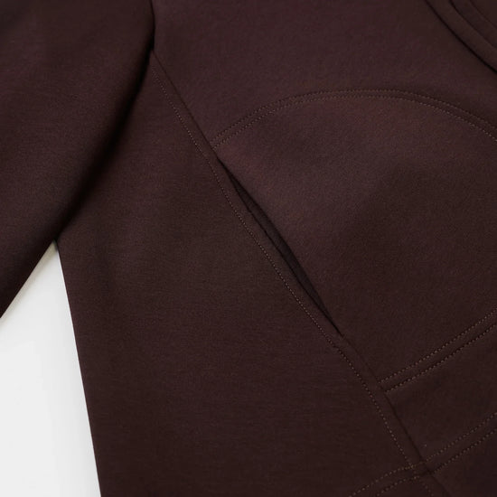 Close-up of a dark brown garment, showing the fabric texture and a curved seam detail.