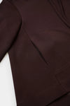 Close-up of a dark brown garment, showing the fabric texture and a curved seam detail.
