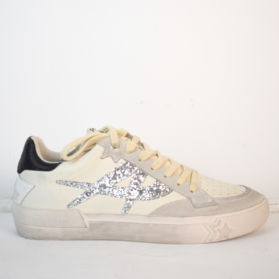 Off white trainers with silver A on the side and black patch on back of heel 