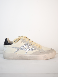 Off white trainers with silver A on the side and black patch on back of heel 