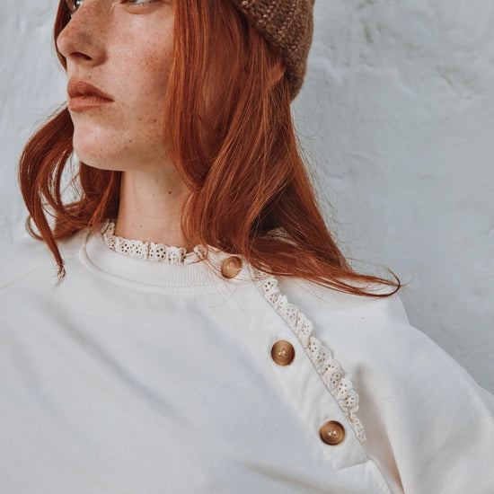 round frill neck cream sweatshirt with button shoulder detailing close up