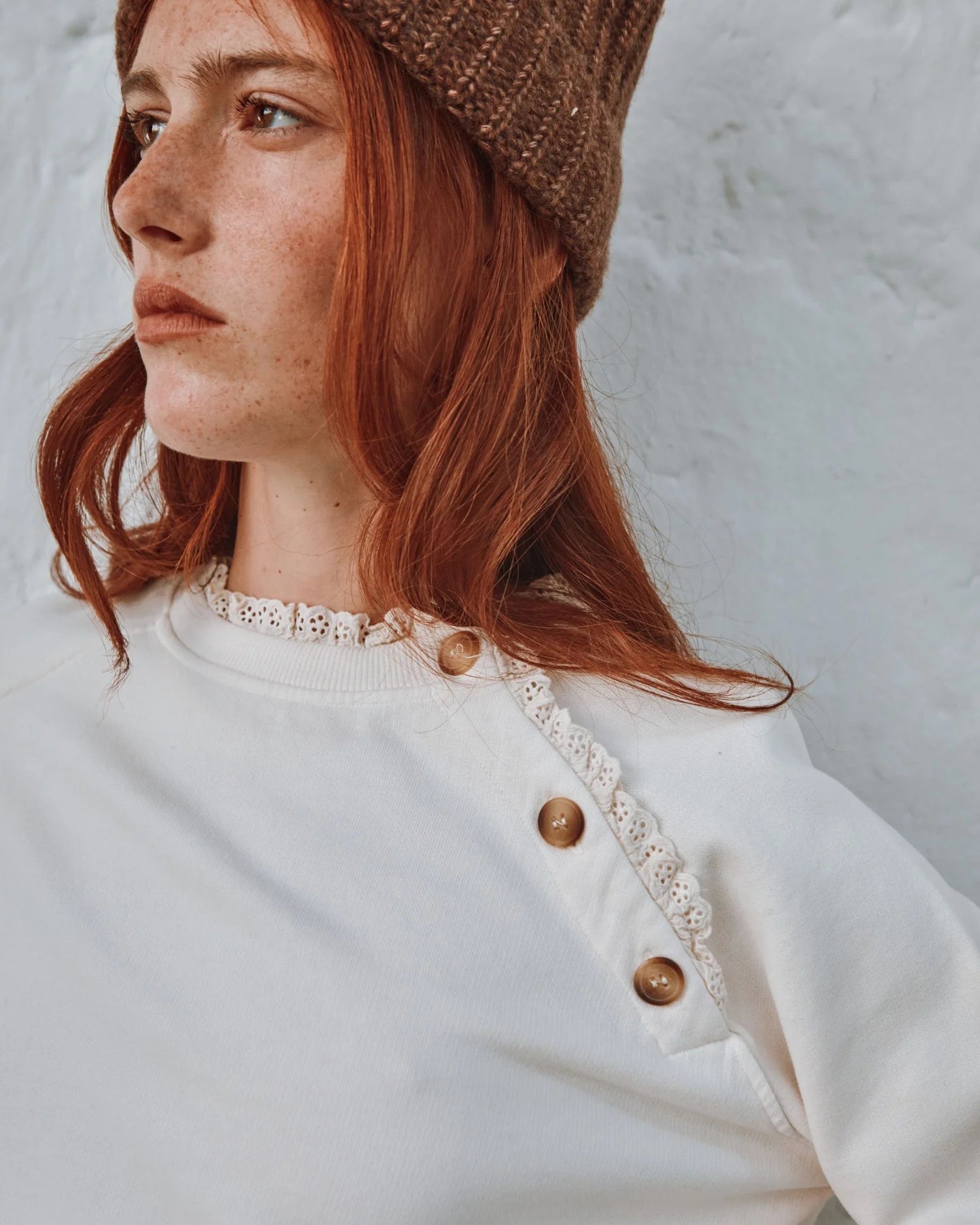 round frill neck cream sweatshirt with button shoulder detailing close up