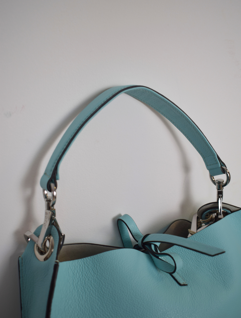 With a handle and a cross body strap.