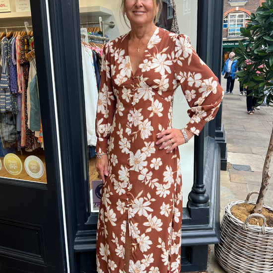 A long vintage style dress with a tan background and a white floral print A long vintage style dress with a tan background and a white floral print 