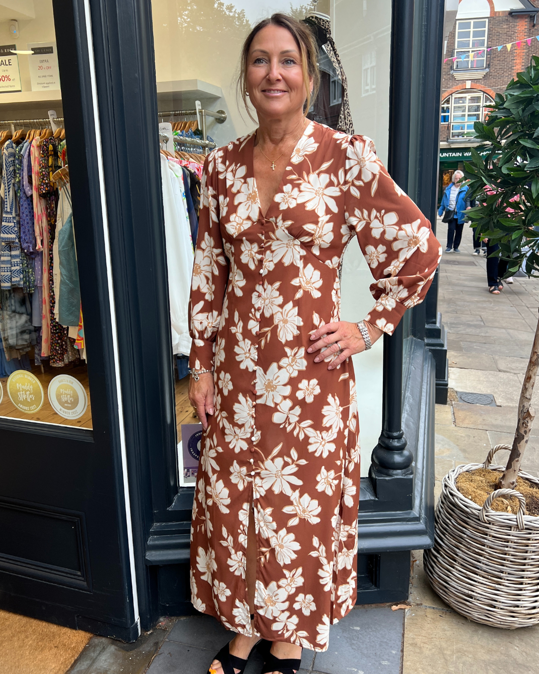 A long vintage style dress with a tan background and a white floral print A long vintage style dress with a tan background and a white floral print 