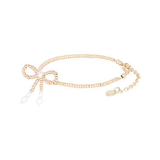 gold beaded bracelet with a bow and pearl details with lobster clasp