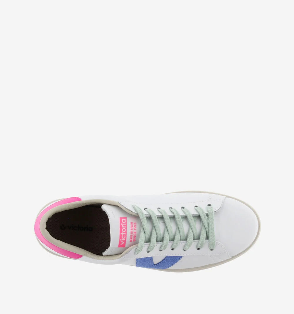 White faux leather trainer with green laces and contrast pink heel tab and suede blue V on outer side