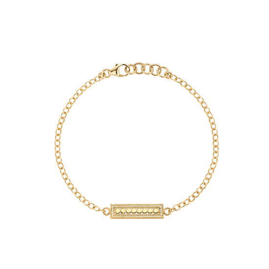 Gold bracelet with a bar charm on a white background from Anna Beck