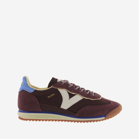 burgundy baseball style trainers with blue back, white v and a serrated tread