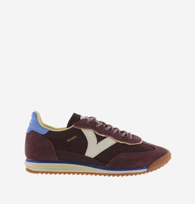 burgundy baseball style trainers with blue back, white v and a serrated tread
