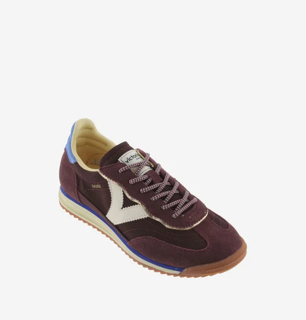 burgundy baseball style trainers with blue back, white v and a serrated tread front view 