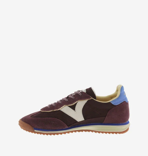 burgundy baseball style trainers with blue back, white v and a serrated tread side view 