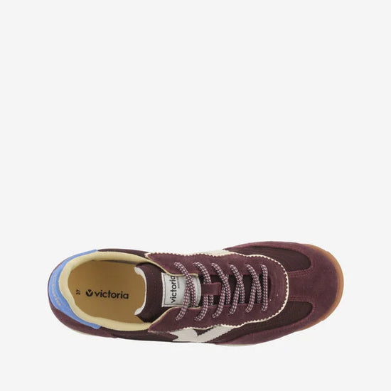 burgundy baseball style trainers with blue back, white v and a serrated tread birds eye view