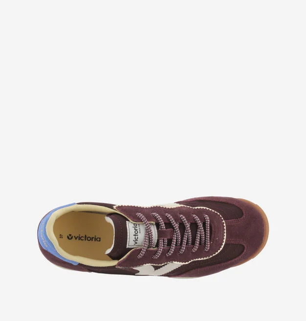 burgundy baseball style trainers with blue back, white v and a serrated tread birds eye view
