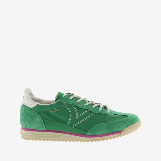 green suede trainers with white laces and serrated tread and pink edging