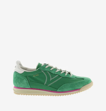 green suede trainers with white laces and serrated tread and pink edging