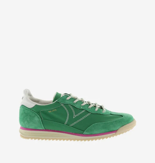 green suede trainers with white laces and serrated tread and pink edging