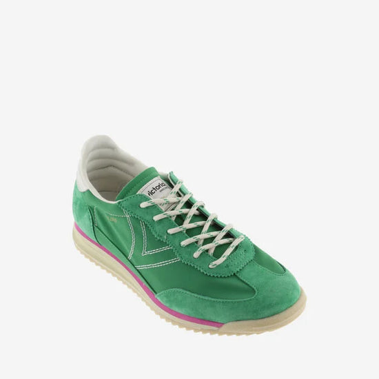 green suede trainers with white laces and serrated tread and pink edging 