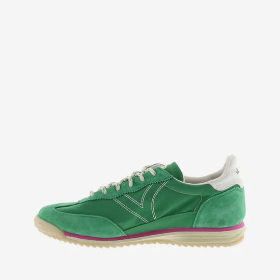 green suede trainers with white laces and serrated tread and pink edging side