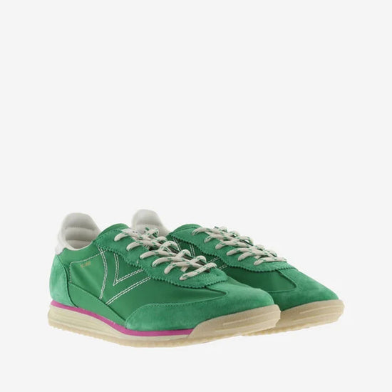 green suede trainers with white laces and serrated tread and pink edging front view