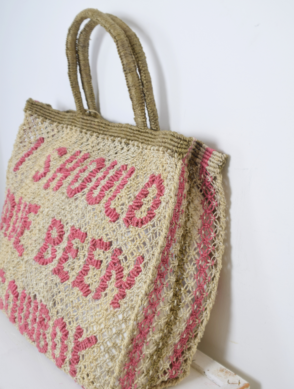 Natural coloured woven bag with pink writing saying 'i should have been a cowboy'