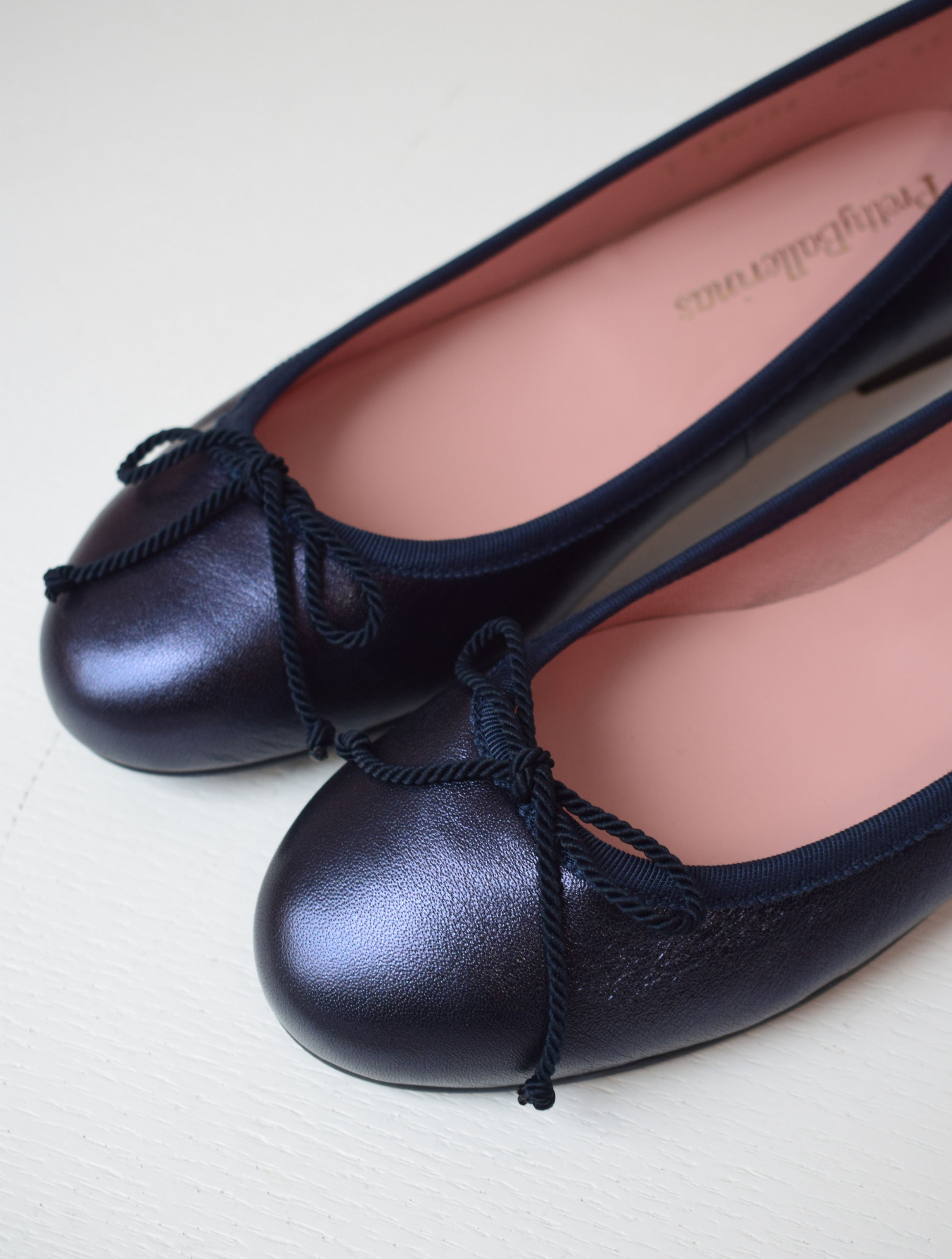 Shimmer navy blue classic round toe ballet pumps with navy thin ribbed binding and navy thin rope bow on toe